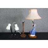 A Doulton style figural table lamp, two white painted metal reading lamps and a turned wooden lamp