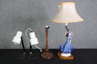 A Doulton style figural table lamp, two white painted metal reading lamps and a turned wooden lamp