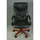 A 1970's style office swivel chair, with black leather upholstery.