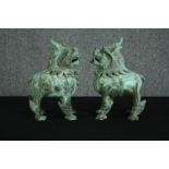 A pair of Chinese Tang style bronzed metal temple lions, with verdigris patination. H.33cm. (each).