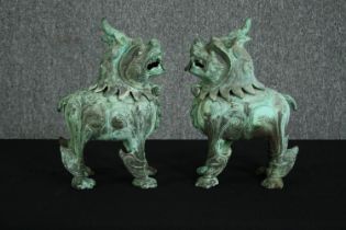 A pair of Chinese Tang style bronzed metal temple lions, with verdigris patination. H.33cm. (each).