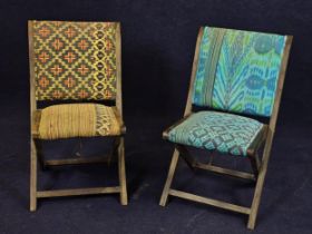 A pair of vintage upholstered folding chairs with teak frames.