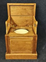 An elm campaign style commode chair with hinged lid. H.84 W.51 D.45cm.