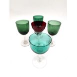 A collection of four Bristol green wine glasses with clear stems and a red glass with twisted