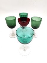 A collection of four Bristol green wine glasses with clear stems and a red glass with twisted