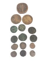 A collection of fifteen ancient coins, one with SPQR and shield with crown.