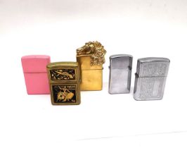 A collection of five Zippo (USA) lighters, a matte pink design, Spanish bull fighter, a gold