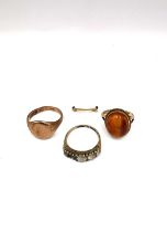 A collection of three 9ct yellow gold rings, including a 9ct ring sizer,an amber and 9ct yellow gold