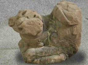 † A 12th century Chinese carved stone temple guardian in the form of a lion. H.43 W.44 D.25cm.