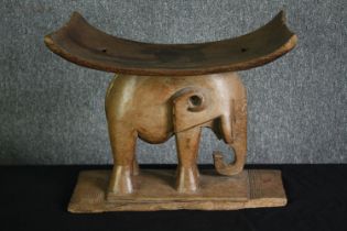 † An Ashanti hardwood stool, carved with an elephant. H.40 W.52 D.30cm.