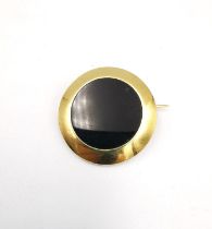 An early 20th century French 18ct yellow gold and onyx circular brooch, set to centre with a