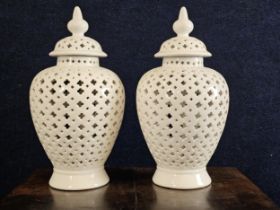 A pair of white glazed ceramic lidded Chinese style temple jars, 20th century, with pierced