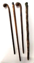 Four early 20th century walking canes, one with miniature clock in body where white metal finial