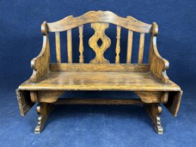 A beech wood bench with stained simulated grain, with drop leaf side flaps. H.106 W.126 D.51.5cm.