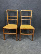 A pair of Edwardian walnut bedroom chairs with caned seats.