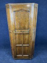 An oak standing corner cupboard. H.183.5 W.87.5 D.55.5cm.