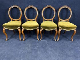 A set of four Victorian carved walnut balloon back dining chairs.