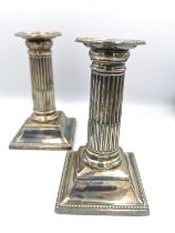 A pair of Victorian weighted silver candlesticks of classical fluted column form on square bases