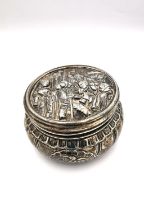 A Victorian repoussé silver lidded box by Elly Isaac Miller, the lid with a continental tavern