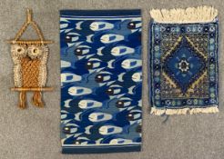 Two wall hangings, one with stylised repeating fish design and a small Eastern rug. L.106 W.62cm (