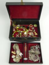 An old jewellery box and contents including a Victorian enamelled locket pendant and chain.