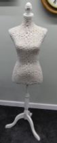 A lace covered tailors/dress makers dummy.