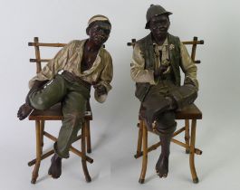 A pair of plaster seated figures naturalistically hand painted. 40 cm high.+
