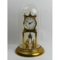 Brass anniversary clock with an enamel dial and glass dome, 30cm. Collection only.