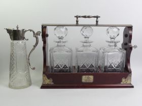 A silver plate and mahogany three bottle tantalus nwith key and a silver plate and cut glass