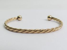 A solid 9ct gold torque bangle, 13.5 grams, 7.8mm.