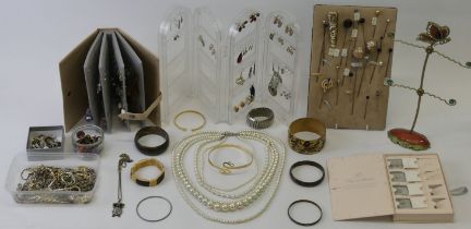 A box of costume jewellery including hat pins and ring stands.