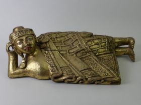 A gilded figure of a recumbent Buddha, probably South Asian. 60 cm.