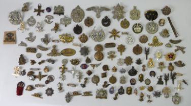 A large collection of military cap badges and buttons, including Manchester, Royal Engineers,
