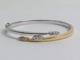 18ct yellow and white gold nine stone diamond hinged bangle, 24.5 grams, 7mm wide.
