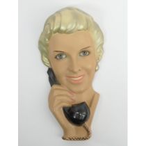 Art Deco plaster wall mask of a lady on the telephone, glass eyes and simulated eye lashes, 39cm.