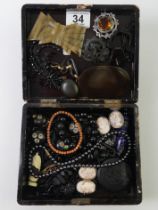 A box containing old jet/French jet beads, Scottish silver brooch, cameos and a lapis pendant.