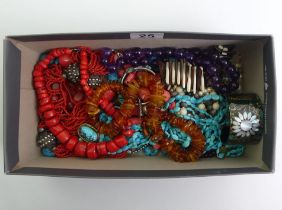 A box containing amethyst, coral, amber, turquoise and other bead necklaces.