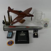 A wooded model of a warplane, Battle of Britain Zippo lighter, Armed Forces veteran enamel badge and