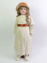 An Armand Marseille bisque head doll number 390. 58cm tall.