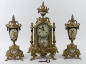 An ornate brass clock garniture with porcelain panels, the clock striking on a bell, 43cm.