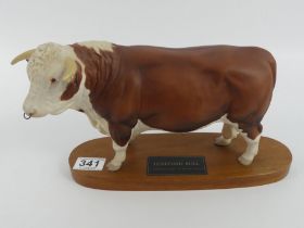 A Beswick Hereford Bull on a wooden plinth designed by Graham Tongue, 18cm x 29cm.