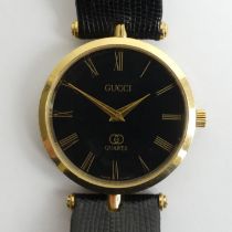 Gucci black face quartz gold tone watch. 32.5 mm inc. button. Condition report: In working order.