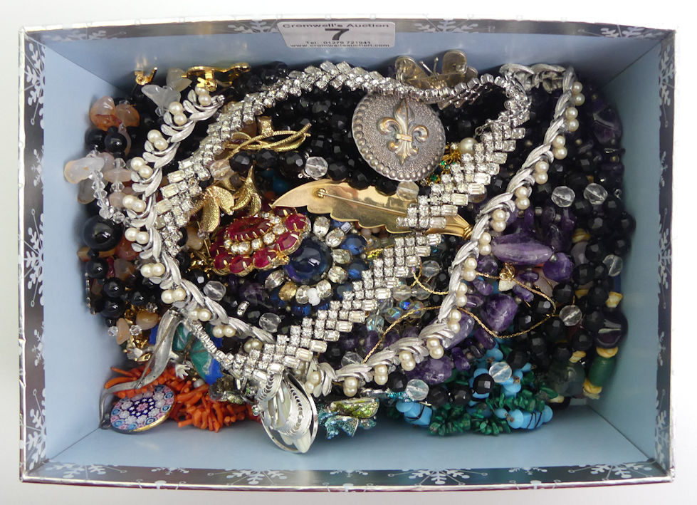 A box of mixed costume jewellery including a Trifari necklace and semi-precious stone necklaces.