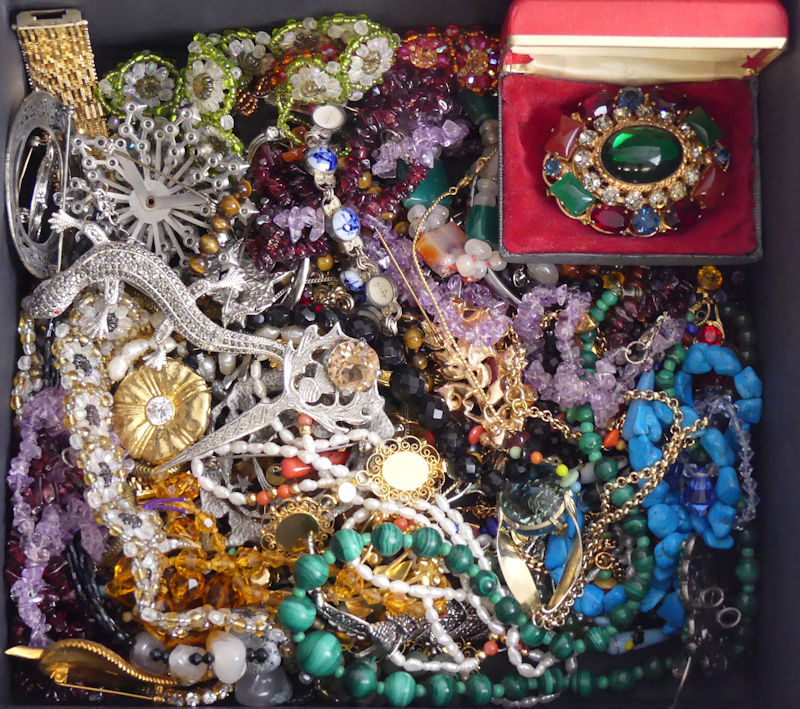 A box of mixed costume jewellery including garnet, amethyst, and malachite necklaces.