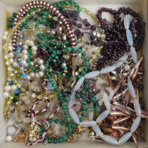 A box of mixed costume jewellery including garnet and other stone necklaces and silver items.