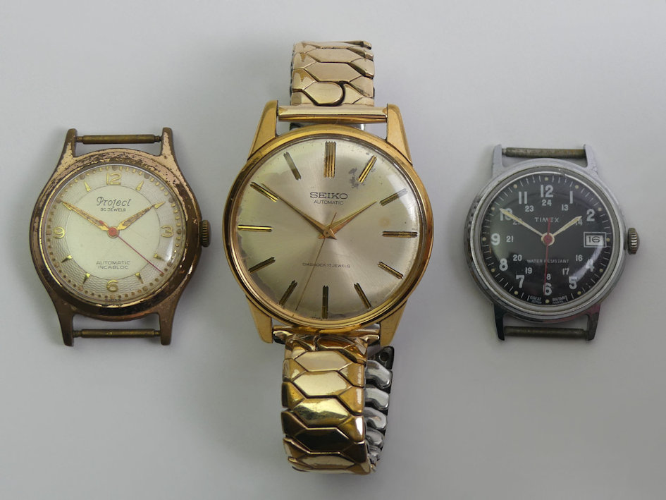 Three gents watches, a Seiko automatic gold tone watch, a Timex black dial watch and a Projects gold