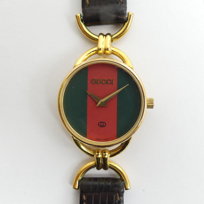 Gucci 6000L quartz gold tone watch on a leather strap, boxed. 25 mm wide inc. button.