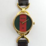 Gucci 6000L quartz gold tone watch on a leather strap, boxed. 25 mm wide inc. button.