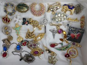 A collection of costume jewellery brooches including a sterling silver thistle example along with