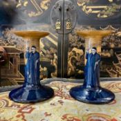ROYAL DOULTON; A PAIR OF EARLY 20TH CENTURY 'MONKS IN THE CELLAR' CANDLESTICKS